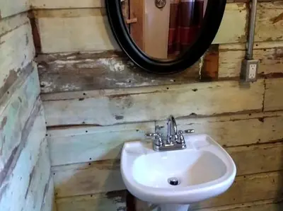 a bathroom with a sink and a mirror at Rustic Octagon-Shaped Cabin for a Glamping Getaway near Huntington, West Virginia in Genoa