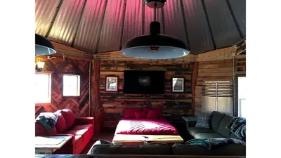 a living room with a couch and a tv at Rustic Octagon-Shaped Cabin for a Glamping Getaway near Huntington, West Virginia in Genoa