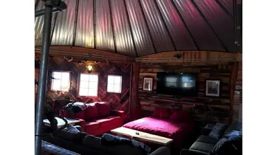 a living room with red furniture in a log cabin at Rustic Octagon-Shaped Cabin for a Glamping Getaway near Huntington, West Virginia in Genoa