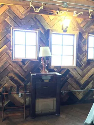a room with two windows and a desk with a lamp at Rustic Octagon-Shaped Cabin for a Glamping Getaway near Huntington, West Virginia in Genoa