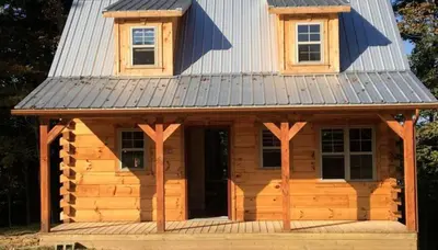 a cabin with a metal roof on top of it at Authentic Stunning Cabin Rental with Private Jacuzzi near Huntington, West Virginia in Genoa