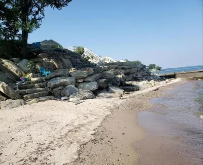 a beach with a rock wall next to the water at Rustic Lakeside Vacation Rental with Beach Access in Vermilion, Ohio in Vermilion