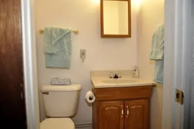 a bathroom with a toilet and a sink and a mirror at Charming Beach Cottage Along Lake Erie near Cleveland, Ohio in Vermilion