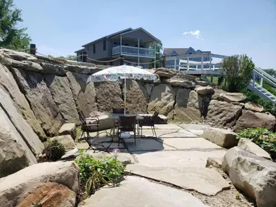 a patio with a table and chairs and an umbrella at Charming Beach Cottage Along Lake Erie near Cleveland, Ohio in Vermilion