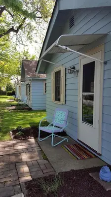 a blue house with a blue chair on the porch at Charming Beach Cottage Along Lake Erie near Cleveland, Ohio in Vermilion