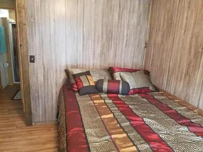 a large bed in a room with a wall at Gorgeous Family-Friendly Cabin with Fire Pit near Huntington, West Virginia in Genoa