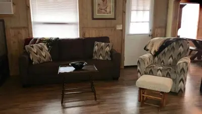 a living room with a couch and a table and a chair at Gorgeous Family-Friendly Cabin with Fire Pit near Huntington, West Virginia in Genoa