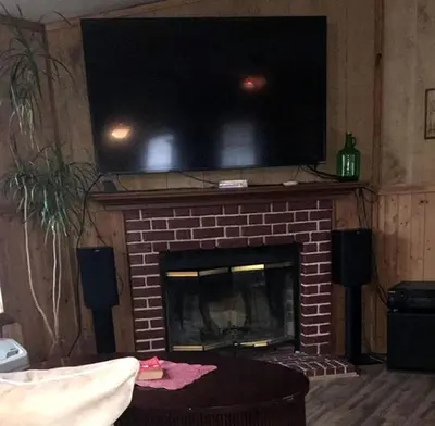 a living room with a fireplace with a television above it at Gorgeous Family-Friendly Cabin with Fire Pit near Huntington, West Virginia in Genoa