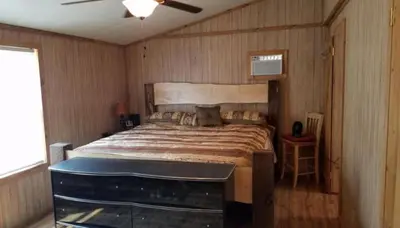 a bedroom with a large bed and a fan at Gorgeous Family-Friendly Cabin with Fire Pit near Huntington, West Virginia in Genoa