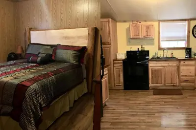 a bedroom with a bed and a small kitchen at Gorgeous Family-Friendly Cabin with Fire Pit near Huntington, West Virginia in Genoa