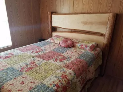 a bedroom with a bed with a quilt on it at Gorgeous Family-Friendly Cabin with Fire Pit near Huntington, West Virginia in Genoa