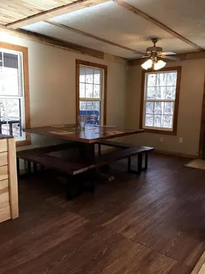 a dining room with a table in the middle of a room at Stunning Getaway Cabin with Expansive Decks near Huntington, West Virginia in Genoa