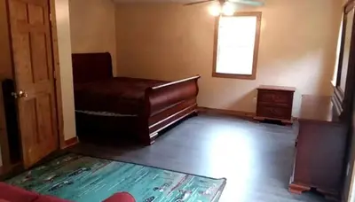 an empty living room with a piano and a window at Stunning Getaway Cabin with Expansive Decks near Huntington, West Virginia in Genoa
