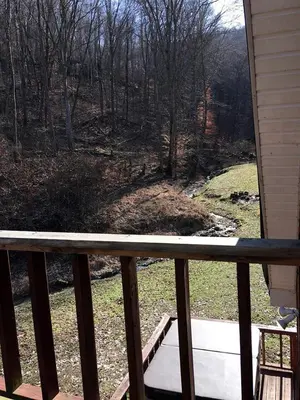 a balcony with a view of a field and trees at Stunning Getaway Cabin with Expansive Decks near Huntington, West Virginia in Genoa