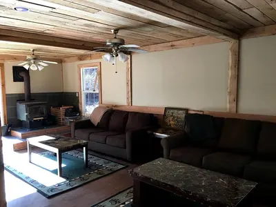 a living room with a couch and a stove at Stunning Getaway Cabin with Expansive Decks near Huntington, West Virginia in Genoa