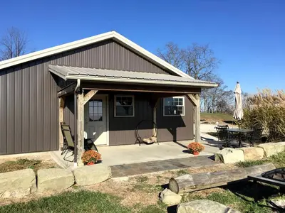 a small house with a porch and a patio at Rustic Cabin in the Countryside near Muskingum River State Park, Ohio in McConnelsville