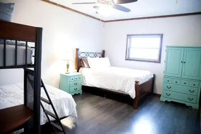 a bedroom with two beds and two dressers at Rustic Cabin in the Countryside near Muskingum River State Park, Ohio in McConnelsville