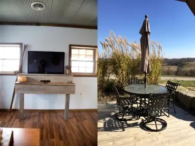 a living room with a table and an umbrella at Rustic Cabin in the Countryside near Muskingum River State Park, Ohio in McConnelsville