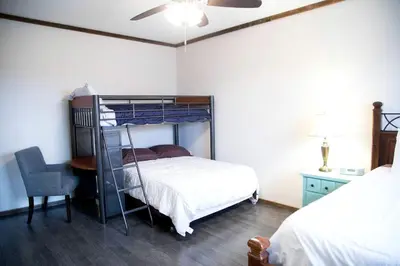 a bedroom with a bunk bed and a desk and a chair at Rustic Cabin in the Countryside near Muskingum River State Park, Ohio in McConnelsville