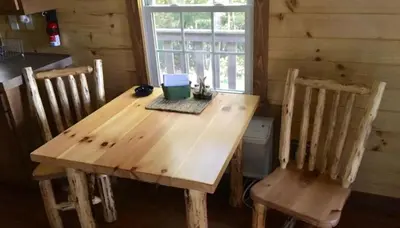 a wooden table and two chairs in a room at Romantic Log Cabin Accommodation with Private Jacuzzi near Huntington, West Virginia in Genoa
