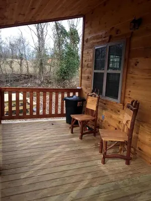 two chairs and a table on a porch of a cabin at Rustic Family-Friendly Accommodation with Jacuzzi near Huntington, West Virginia in Genoa