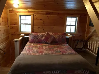 a bedroom with a bed in a wooden cabin at Rustic Family-Friendly Accommodation with Jacuzzi near Huntington, West Virginia in Genoa
