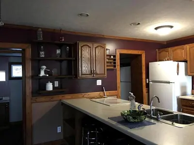 a kitchen with a sink and a white refrigerator at Gorgeous Vacation Cabin for Groups with Stylish Interior near Huntington, West Virginia in Genoa