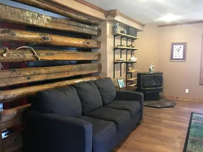 a living room with a couch and a wooden wall at Gorgeous Vacation Cabin for Groups with Stylish Interior near Huntington, West Virginia in Genoa