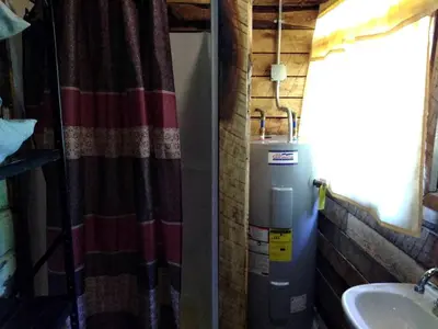 a bathroom with a water heater and a sink at Unique Rustic Yurt Rental for a Peaceful Retreat near Huntington, West Virginia in Genoa