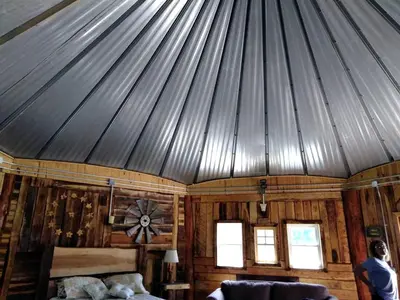a person standing in a room with a roof at Unique Rustic Yurt Rental for a Peaceful Retreat near Huntington, West Virginia in Genoa