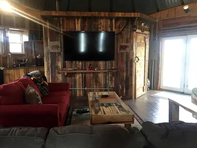 a living room with a couch and a coffee table at Unique Rustic Yurt Rental for a Peaceful Retreat near Huntington, West Virginia in Genoa