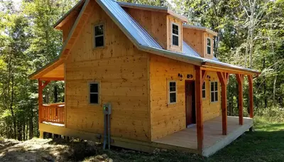 a wooden cabin with a gambrel roof at Cozy Family-Friendly Cabin with Private Outdoor Jacuzzi near Huntington, West Virginia in Genoa
