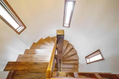 a wooden spiral staircase in a room with skylights at Stunning Home Away From Home in New Albany, Ohio, For Restful Escapes to Nature in New Albany