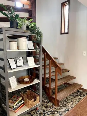 a stairwell with wooden steps and a shelf with books at Stunning Home Away From Home in New Albany, Ohio, For Restful Escapes to Nature in New Albany