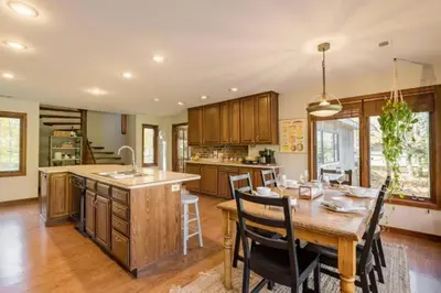 a kitchen with a wooden table and a dining room at Stunning Home Away From Home in New Albany, Ohio, For Restful Escapes to Nature in New Albany