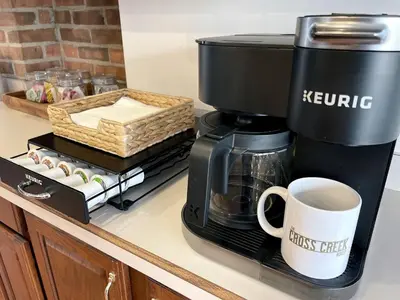 a coffee maker and a coffee cup on a counter at Stunning Home Away From Home in New Albany, Ohio, For Restful Escapes to Nature in New Albany