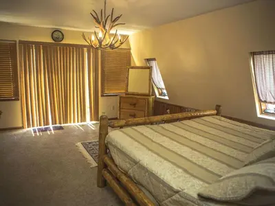 a bedroom with a large bed and a chandelier at Magnificent A-Frame Cabin Rental in the Trees close to Hocking Hills State Park, Ohio in Laurelville
