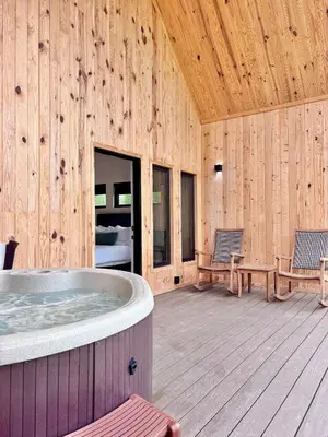 a room with a hot tub in a wooden building at Knob Hill at Three Suns Cabins in Stanton