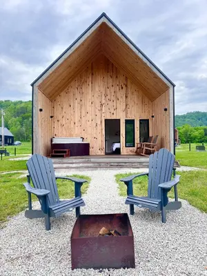 two chairs in front of a building with a piano at Knob Hill at Three Suns Cabins in Stanton