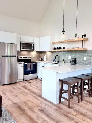 a kitchen with white appliances and wooden floors at Knob Hill at Three Suns Cabins in Stanton
