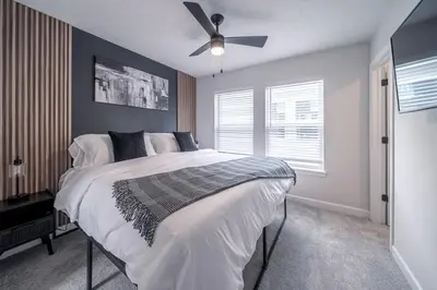 a bedroom with a large bed with a ceiling fan at Arcade Game Room! Luxury New 3BR CLE Clinic UnivCircle Little Italy in Cleveland