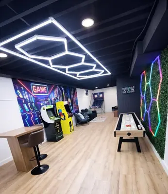 a room with a ping pong table and a video game at Arcade Game Room! Luxury New 3BR CLE Clinic UnivCircle Little Italy in Cleveland