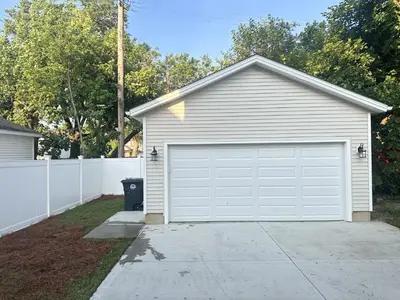 a house with a white garage door in a driveway at Arcade Game Room! Luxury New 3BR CLE Clinic UnivCircle Little Italy in Cleveland