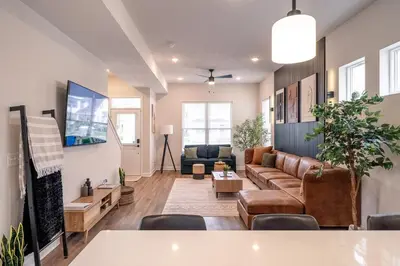 a living room with a couch and a table at Arcade Game Room! Luxury New 3BR CLE Clinic UnivCircle Little Italy in Cleveland