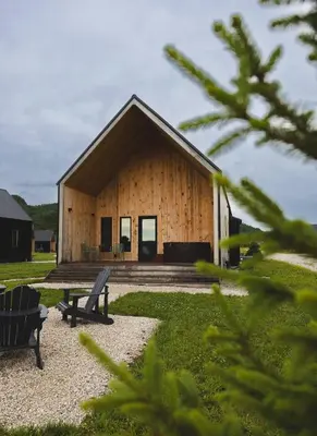 a wooden building with a bench in front of it at Wildflower Walk at Three Suns Cabins in Stanton