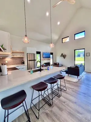 a kitchen and living room with a counter and stools at Wildflower Walk at Three Suns Cabins in Stanton