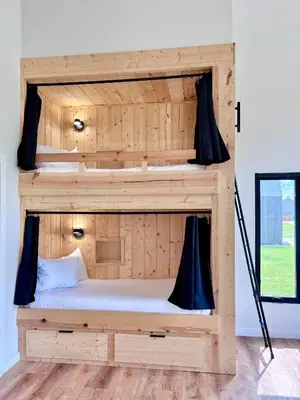 two bunk beds in a room with a window at River's Edge at Three Suns Cabins in Stanton