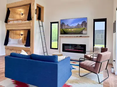 a living room with a blue couch and a bunk bed at River's Edge at Three Suns Cabins in Stanton