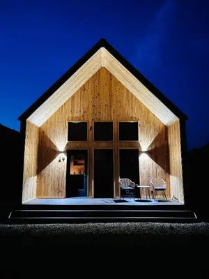 a house with two chairs and a table in front of it at River's Edge at Three Suns Cabins in Stanton