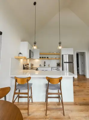 a kitchen with two chairs and a white counter top at River's Edge at Three Suns Cabins in Stanton